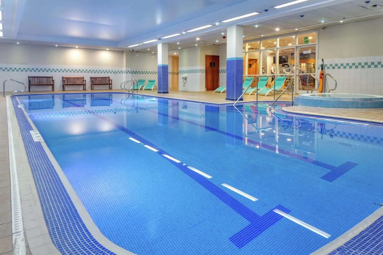 a large indoor swimming pool with blue water at Hilton Newcastle Tyne Bridge in Newcastle upon Tyne